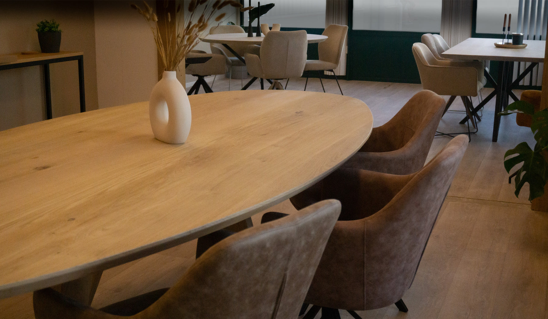 Foto van de showroom met een ovale, ronde en rechthoekige eettafel